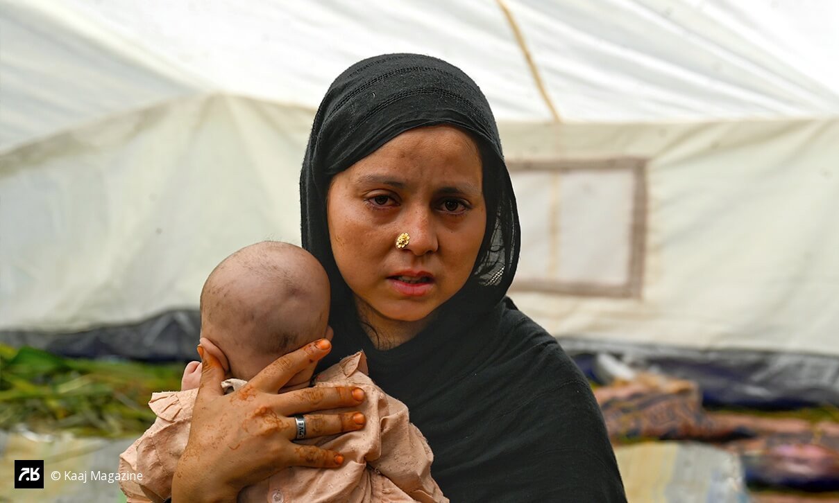 In Vadir village, a woman who lost four relatives holds her newborn, the only child to survive.