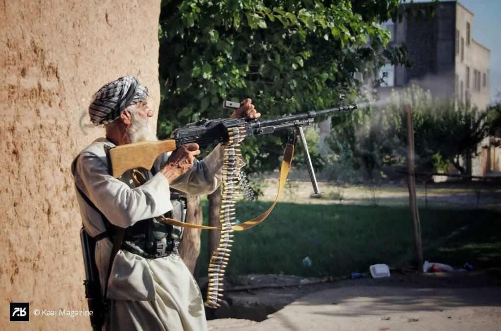 Elderly man firing a machine gun