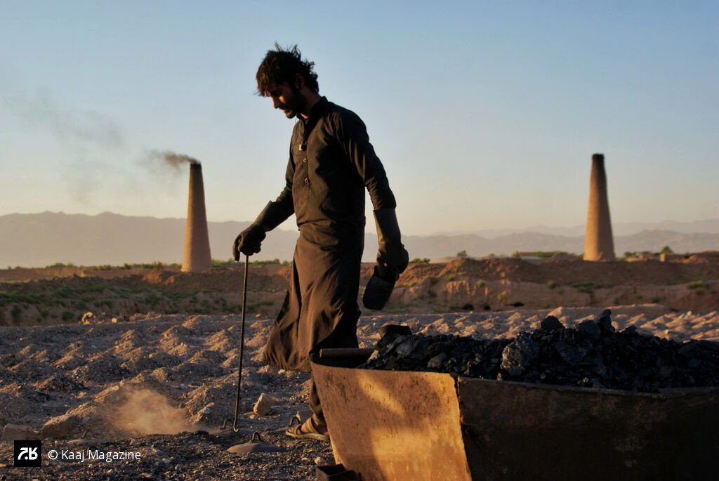 Worker walking past a smoking kiln