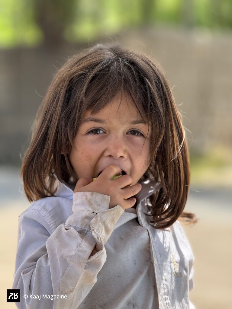 Young girl eating a piece of fruit