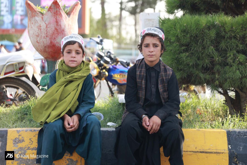 Two boys sitting on a curb