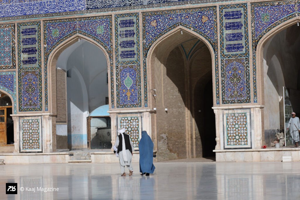 A couple in courtyard of a blue-tiled mosque