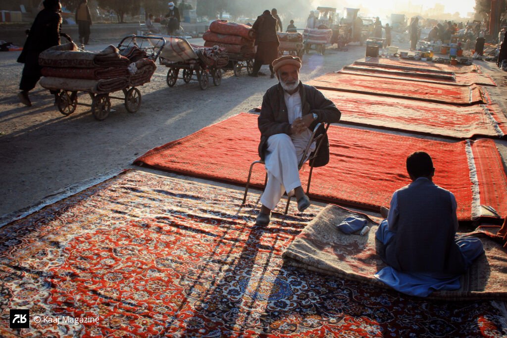 Rug merchant sitting at a dusty market