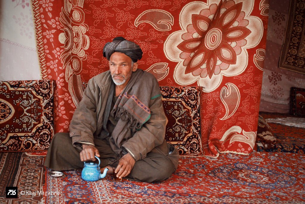 Man with a blue teapot on a rug