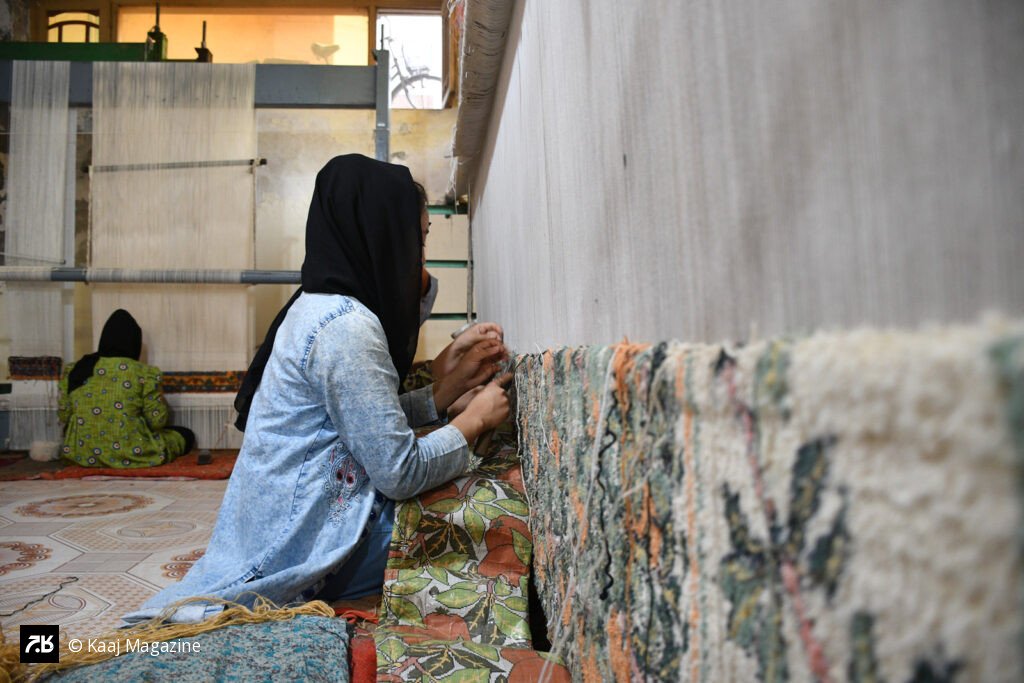 An Afghan girl weaving a traditional carpet