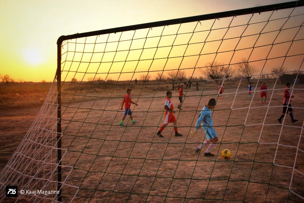 Boys playing soccer at golden hour
