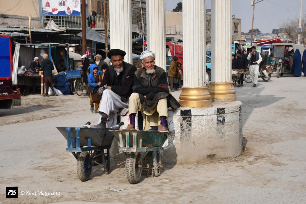 Two men resting on wheelbarrows