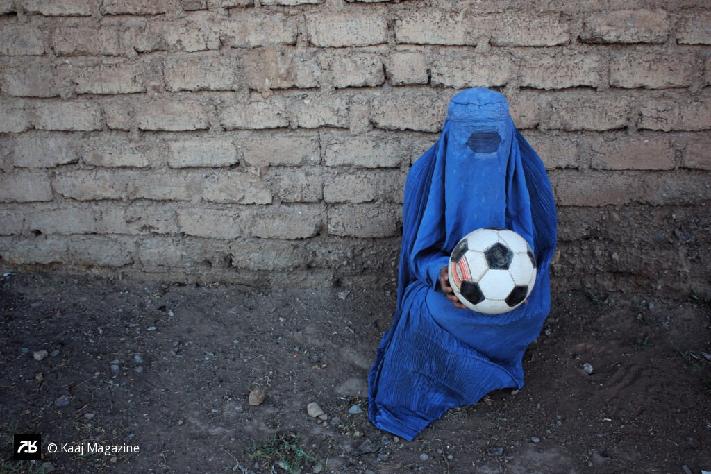 Woman in burqa holding a soccer ball