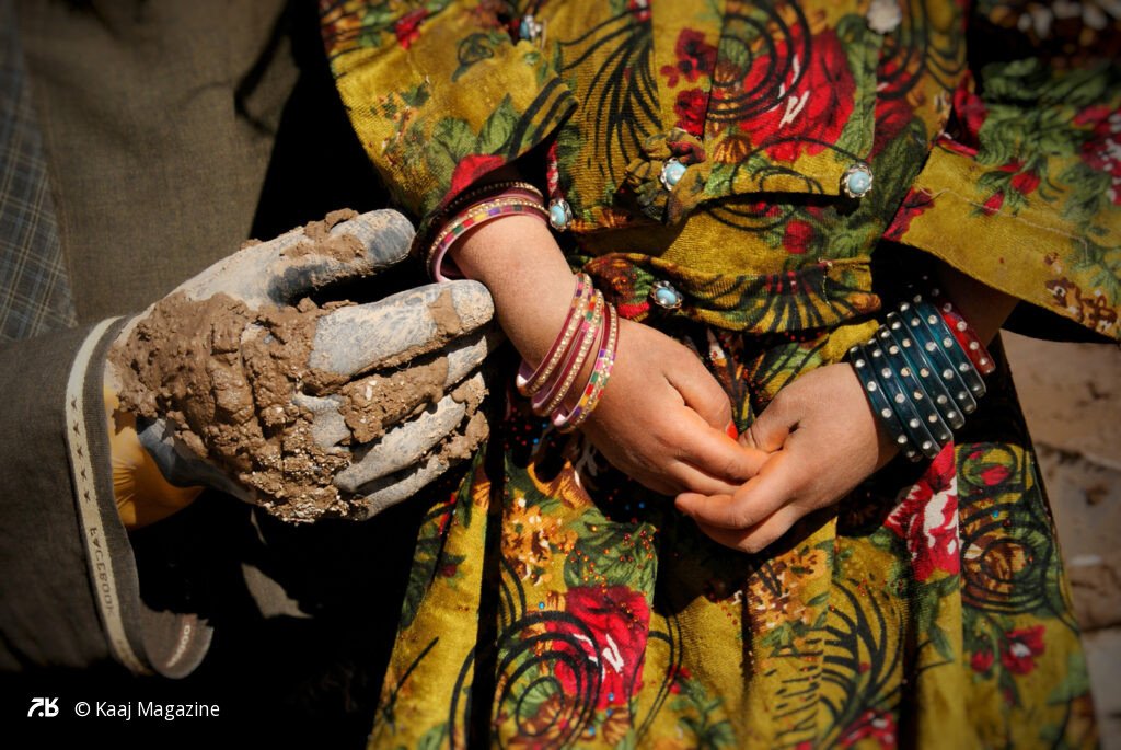 Muddy hand holding a child's wrist