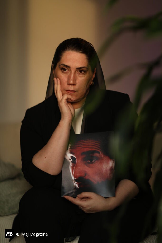Woman holding a photo of "Ahmad Shah Masoud"